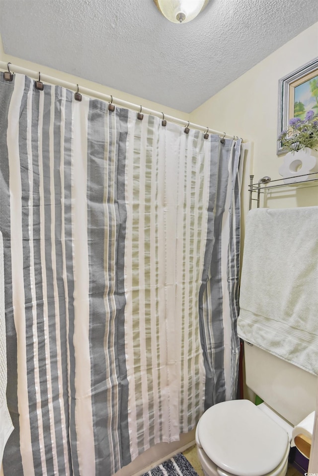 bathroom featuring a textured ceiling and toilet