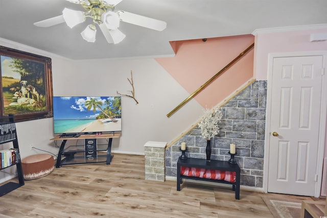 living room featuring ceiling fan, ornamental molding, and wood-type flooring