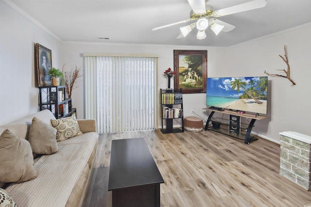 living room with ceiling fan, ornamental molding, and light hardwood / wood-style floors