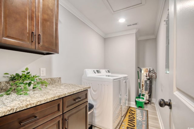 laundry area with light wood-type flooring, ornamental molding, cabinets, and separate washer and dryer