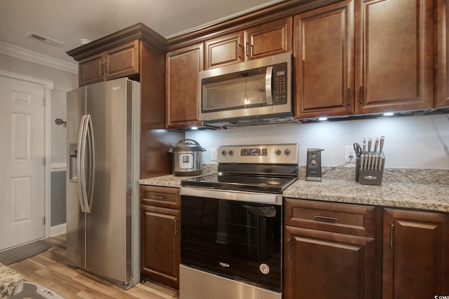 kitchen featuring light hardwood / wood-style floors, light stone counters, crown molding, and stainless steel appliances