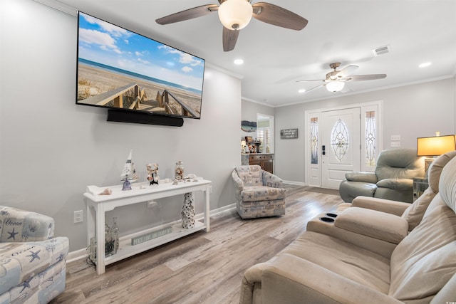 living room featuring light wood-type flooring, ceiling fan, and ornamental molding