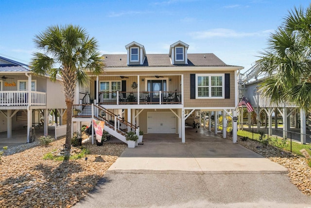 beach home with covered porch, ceiling fan, and a garage