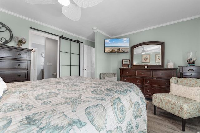 bedroom featuring ceiling fan, light hardwood / wood-style flooring, a barn door, and crown molding