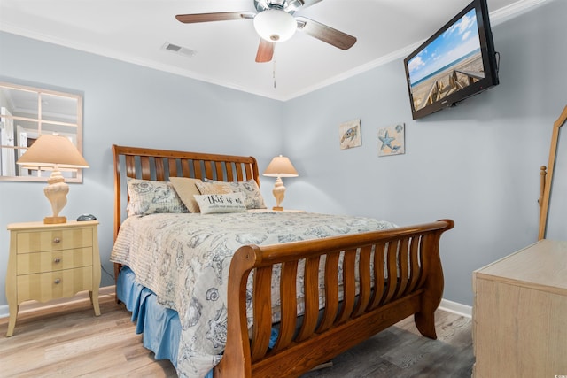 bedroom featuring ceiling fan, light hardwood / wood-style flooring, and crown molding