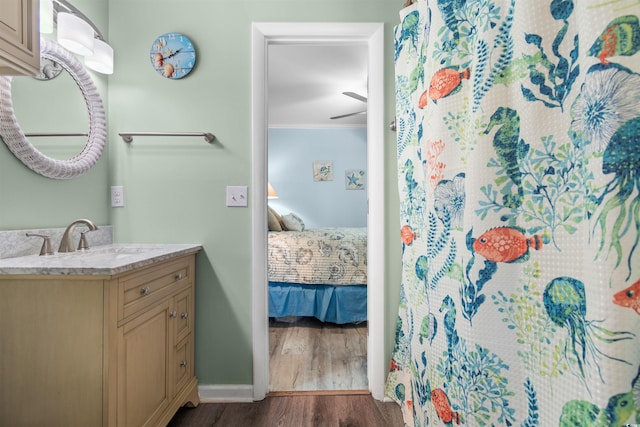 bathroom with wood-type flooring, vanity, and ornamental molding