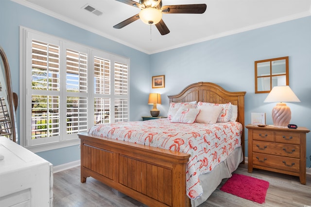 bedroom featuring ceiling fan, crown molding, and light wood-type flooring