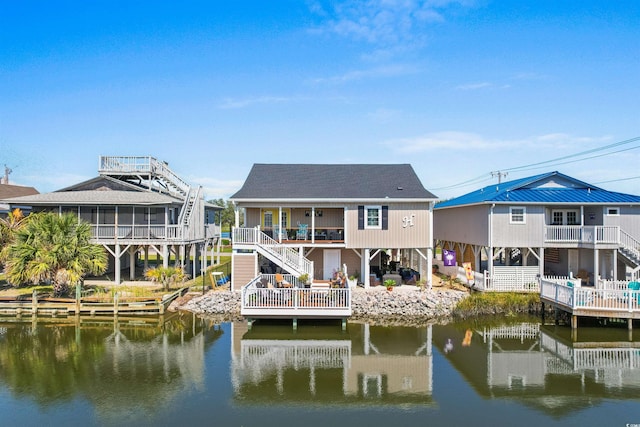 back of house featuring a sunroom and a water view