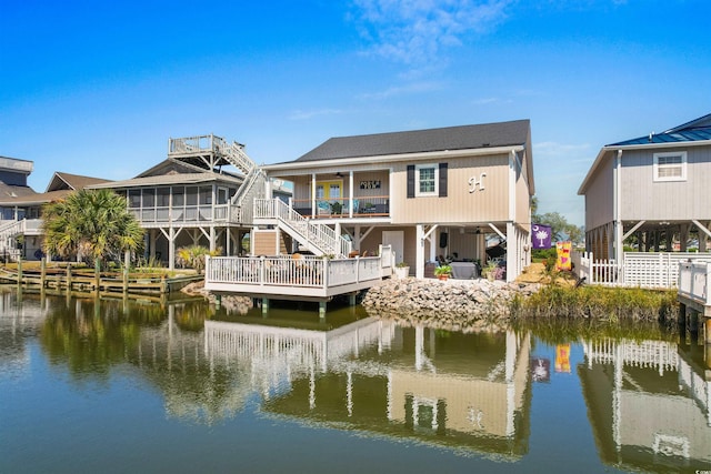 rear view of property featuring a sunroom and a water view