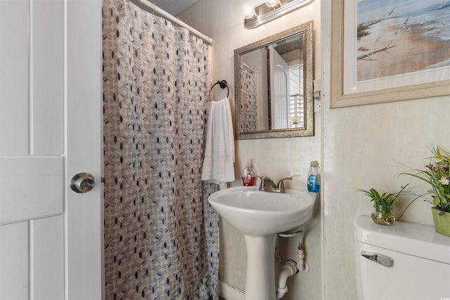 bathroom with sink, toilet, and a shower with shower curtain