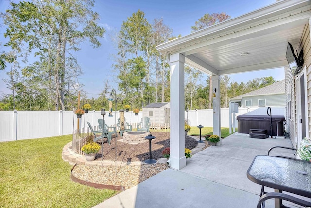 view of patio / terrace with a fire pit, a hot tub, and a storage unit