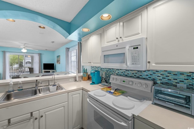 kitchen featuring white appliances, white cabinets, a textured ceiling, decorative backsplash, and sink