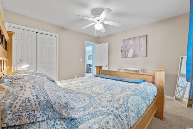 carpeted bedroom with a textured ceiling, a closet, and ceiling fan