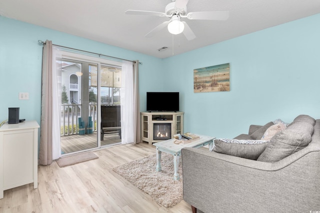 living room featuring light wood-type flooring and ceiling fan