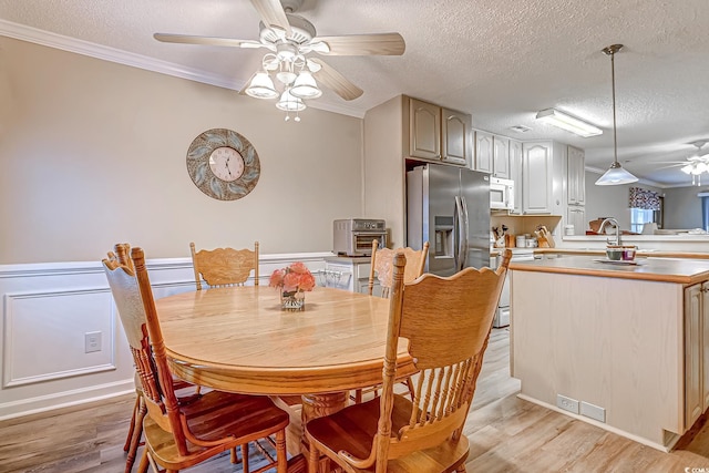 880 Fairway Dr Unit 302Bb, Longs, SC 29568 - dining area featuring a ceiling fan, light wood-style flooring, ornamental molding, and a textured ceiling