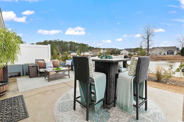 view of patio / terrace with a water view, exterior bar, and outdoor lounge area