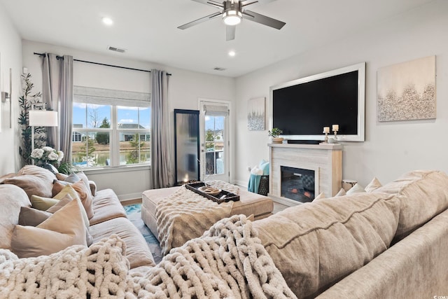 living room with ceiling fan and a high end fireplace