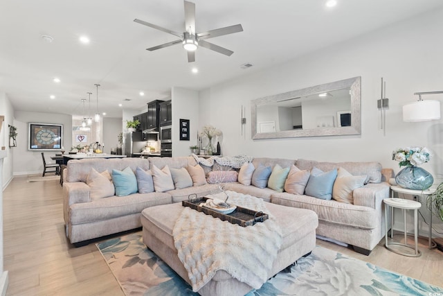 living room featuring ceiling fan and light hardwood / wood-style floors