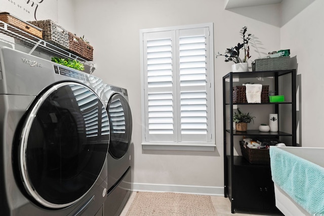 laundry area featuring washing machine and clothes dryer and light tile patterned flooring