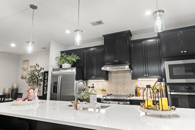 kitchen featuring appliances with stainless steel finishes, decorative backsplash, sink, pendant lighting, and light stone counters