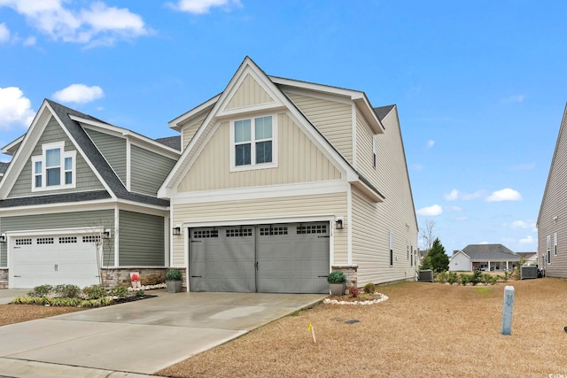 craftsman house with central AC unit and a garage