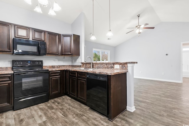 kitchen featuring dark brown cabinetry, sink, black appliances, and hanging light fixtures