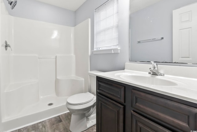 bathroom featuring vanity, hardwood / wood-style floors, toilet, and walk in shower