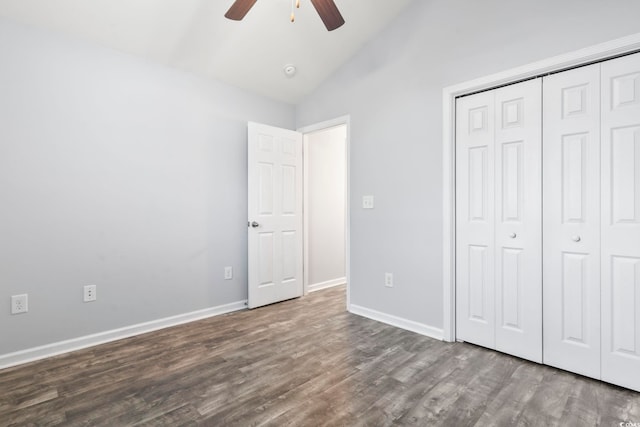 unfurnished bedroom featuring ceiling fan, lofted ceiling, dark hardwood / wood-style flooring, and a closet