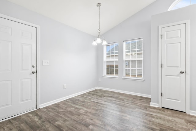 unfurnished dining area featuring wood-type flooring, lofted ceiling, and a chandelier