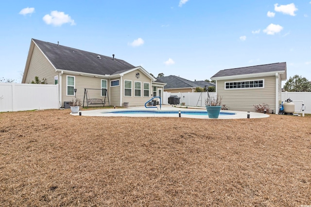 back of house featuring a fenced in pool, a patio, and a yard