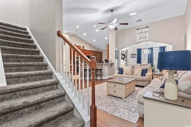 living room with light hardwood / wood-style flooring, a high ceiling, and ceiling fan