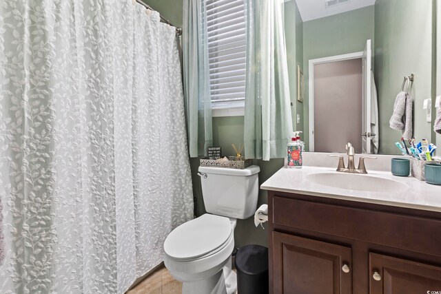 bathroom with toilet, tile patterned flooring, and vanity