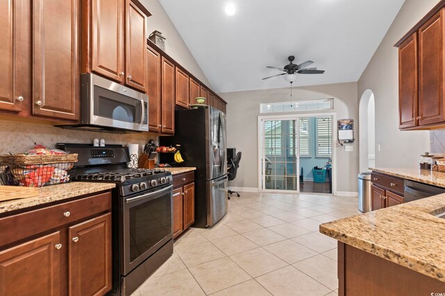 kitchen with light tile patterned floors, appliances with stainless steel finishes, tasteful backsplash, and vaulted ceiling