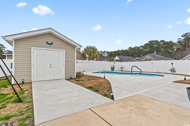 view of swimming pool featuring a patio area and an outdoor structure