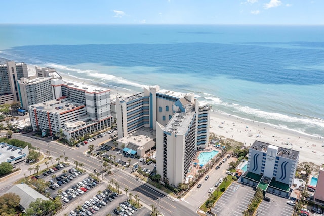 drone / aerial view featuring a water view and a view of the beach