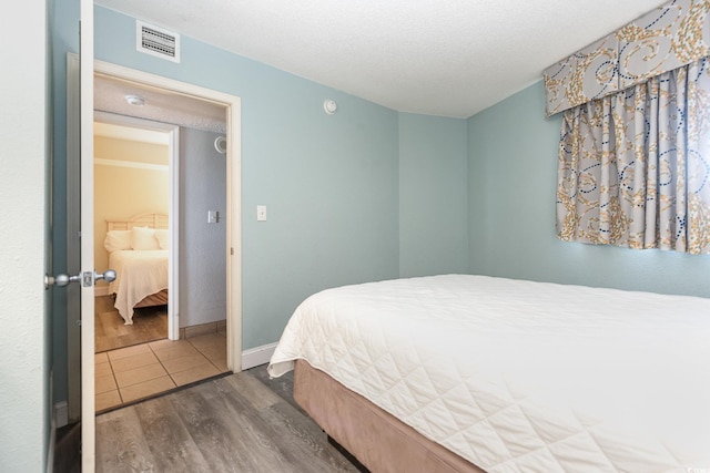 bedroom with dark wood-type flooring and a textured ceiling