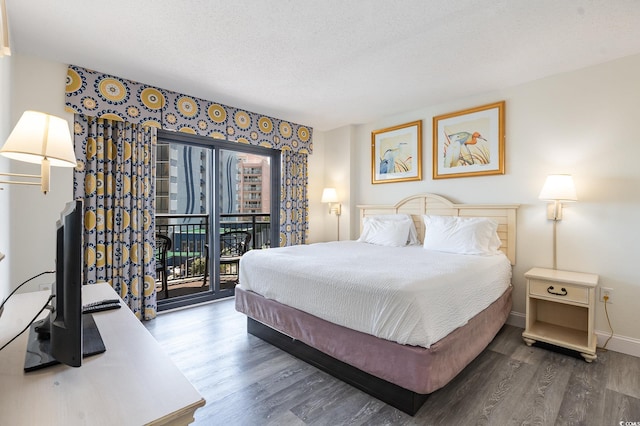 bedroom with access to exterior, a textured ceiling, and dark hardwood / wood-style flooring