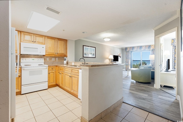 kitchen with kitchen peninsula, white appliances, sink, and crown molding