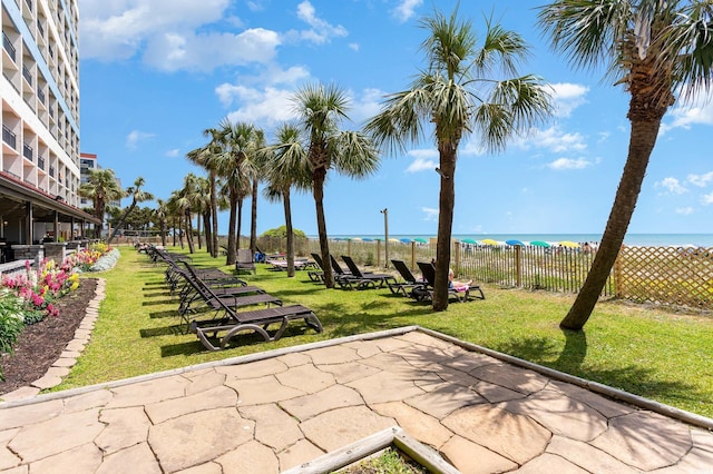 view of property's community featuring a patio area, a water view, and a yard