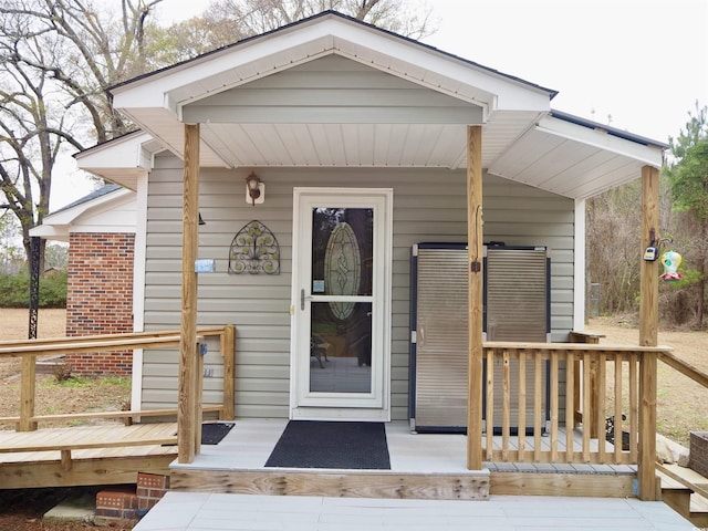 view of exterior entry featuring covered porch