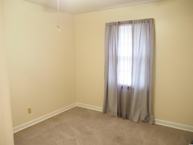 unfurnished room featuring light colored carpet