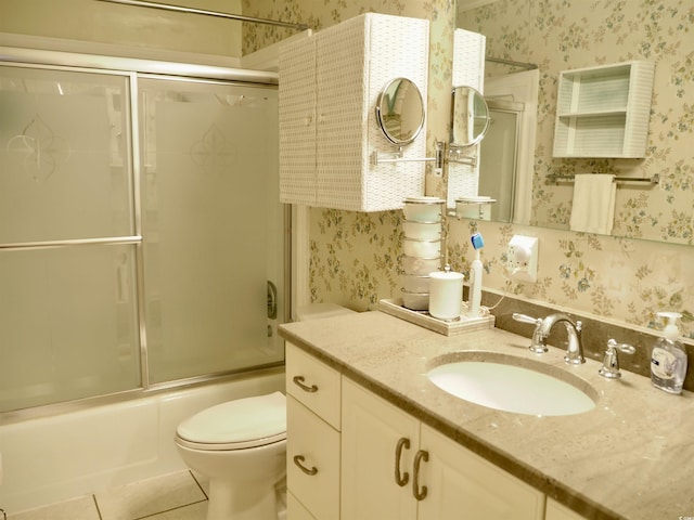 full bathroom featuring vanity, tile patterned floors, shower / bath combination with glass door, and toilet