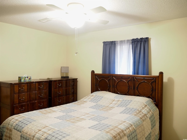 bedroom with ceiling fan and a textured ceiling