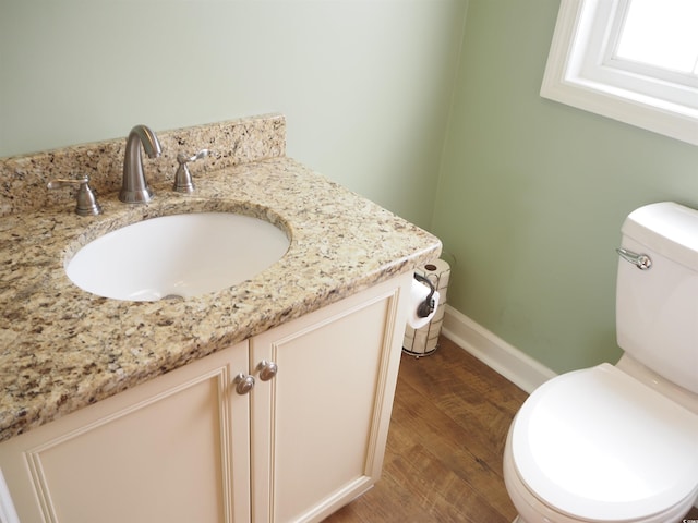 bathroom with vanity, toilet, and hardwood / wood-style floors