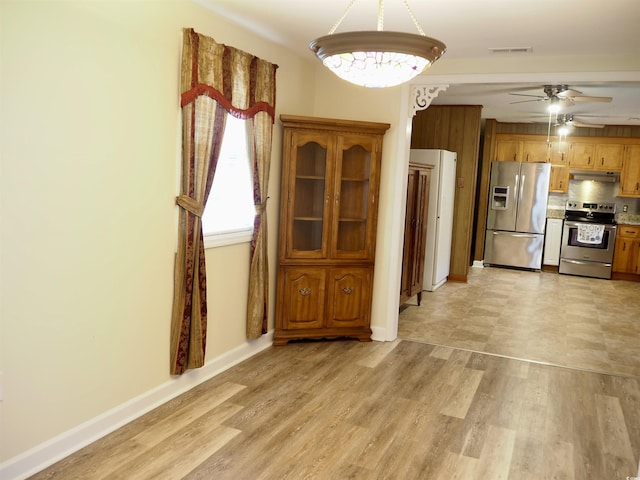 kitchen with stainless steel appliances, tasteful backsplash, ceiling fan, and light hardwood / wood-style flooring