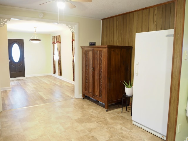 foyer entrance featuring crown molding, ceiling fan, and a textured ceiling