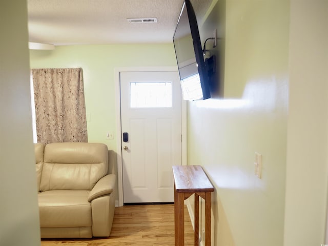 entryway with a textured ceiling and light hardwood / wood-style flooring