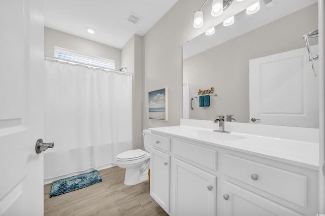 full bathroom featuring vanity, toilet, shower / tub combo, and hardwood / wood-style floors