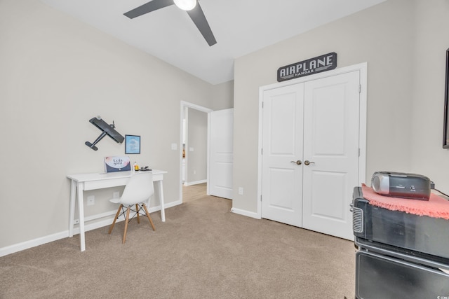 carpeted home office featuring ceiling fan