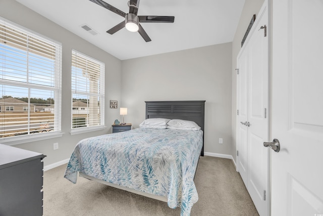 bedroom featuring light carpet, a closet, and ceiling fan